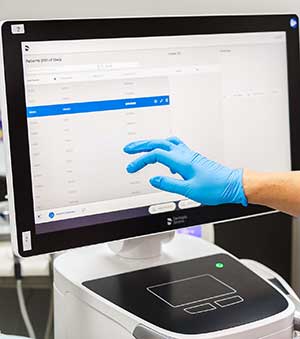 Gloved handing touching a computer screen